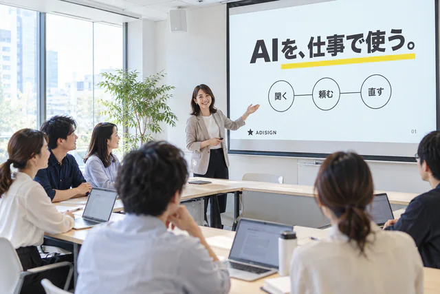 会議室のスクリーンの前で講師が話し、社員が聞いているAIセミナーの様子
