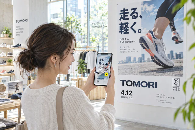 ショップの壁のポスターにスマホをかざすと、紙面からシューズの3Dモデルが立ち上がるAR体験